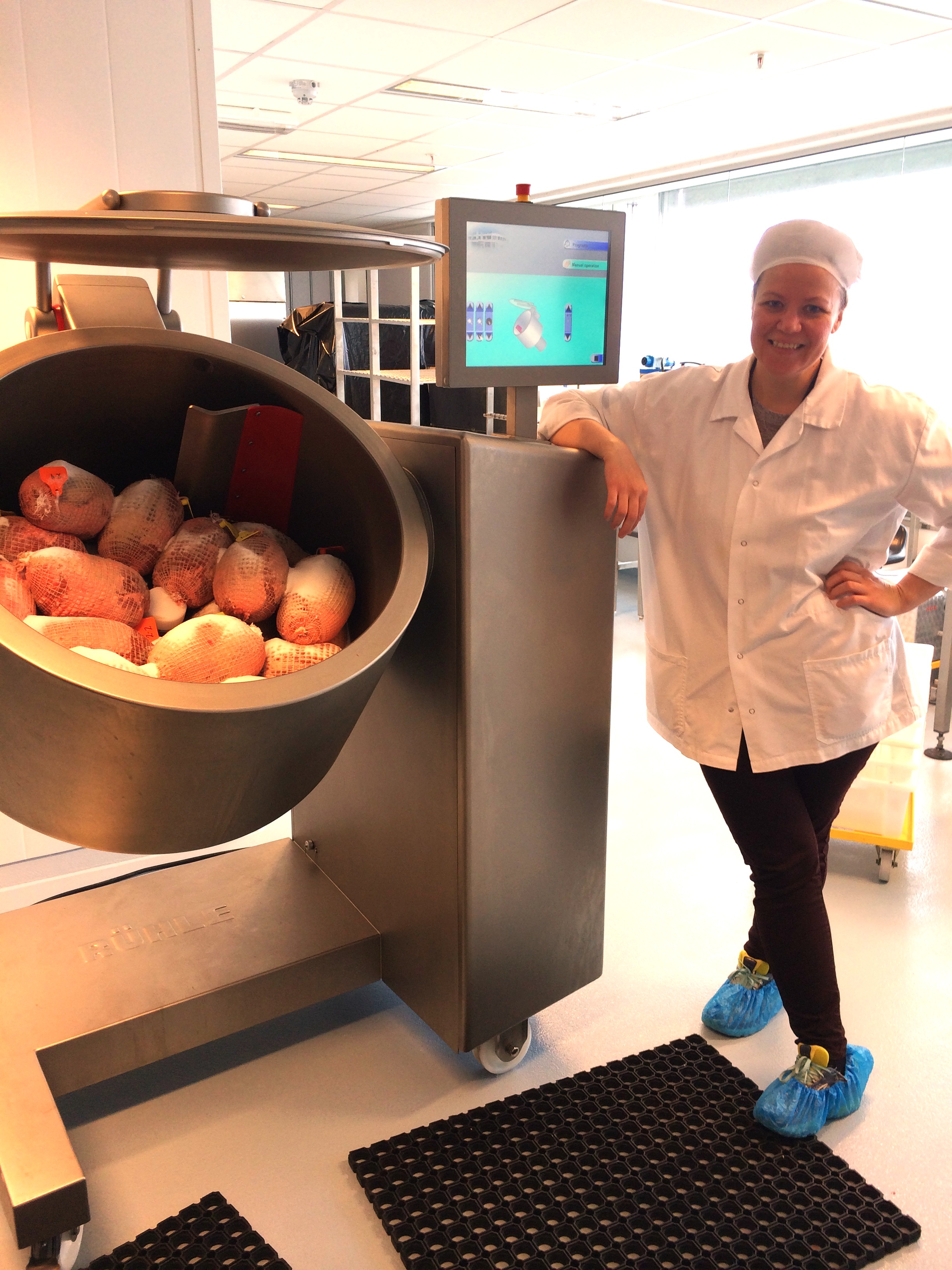 Salttrommel fylt med nettede fenarull klare for salttromling, og en person står ved siden av.