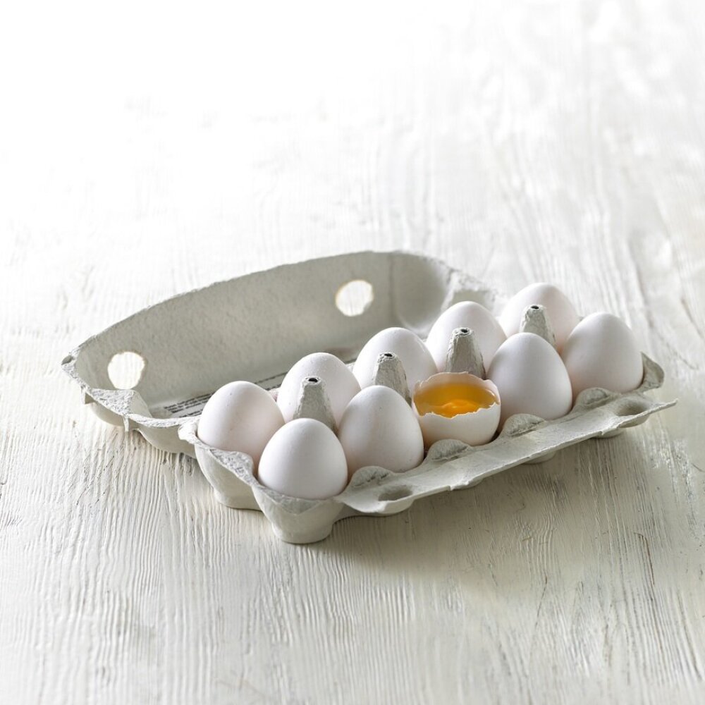 Eggekartong med hvite egg og ett knekt egg