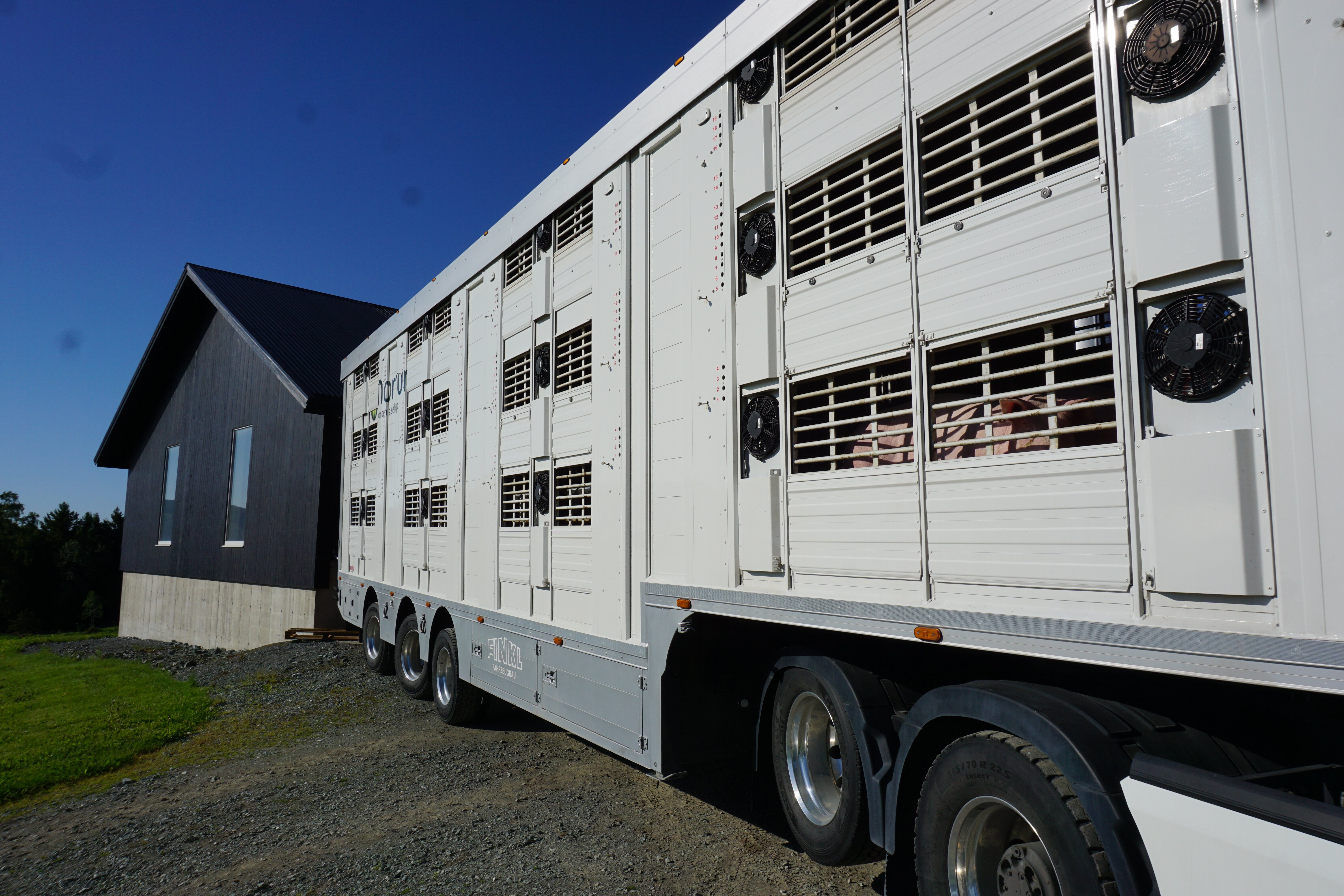 En transportbil med ventilasjonsvifter parkert utenfor en bygning.